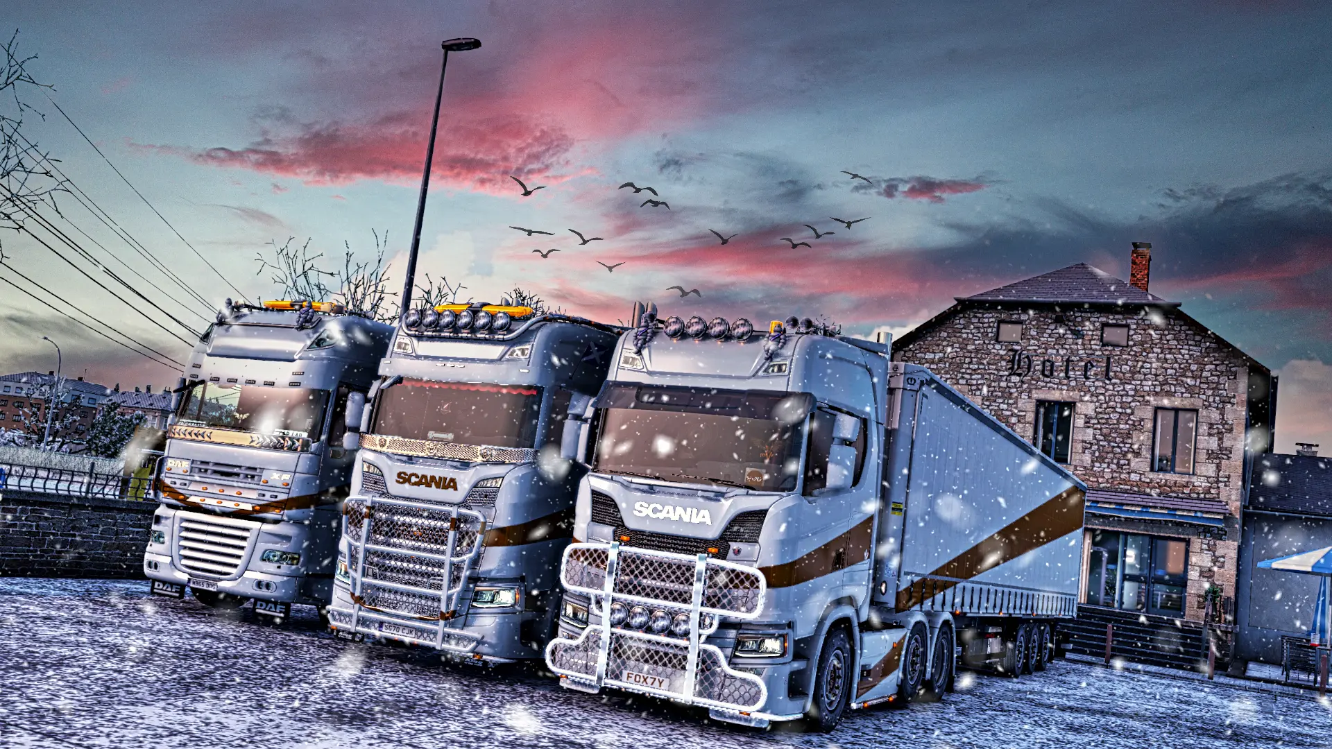 Three GPE trucks parked in a hotel, all wearing the new gold and white paint job. Birds are flying over the trucks and the sky is blue and pink